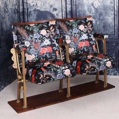 set of two vintage cinema seats refurbished and upholstered in a black floral velvet with a tiger peeking out behind the roses