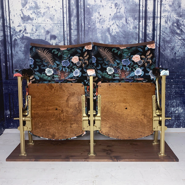 set of two vintage cinema seats refurbished and upholstered in a black floral velvet with a tiger peeking out behind the roses