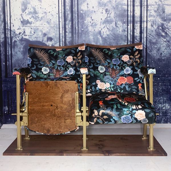 set of two vintage cinema seats refurbished and upholstered in a black floral velvet with a tiger peeking out behind the roses