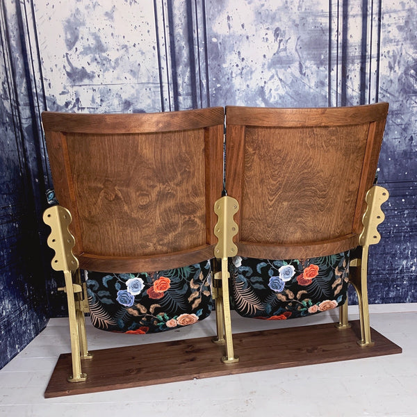 rear view ofset of two vintage cinema seats refurbished and upholstered in a black floral velvet with a tiger peeking out behind the roses