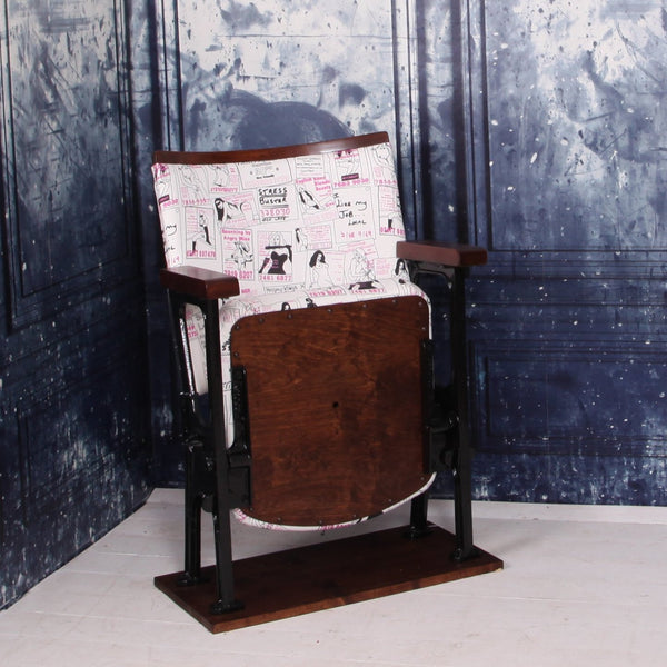 a vintage cinema seat upholstered in a call girl fabric with black gloss legs against a blue marbled wall