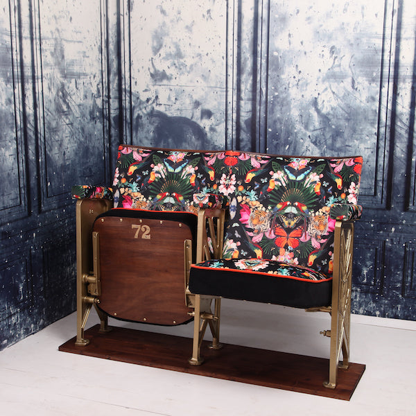 a set of two vintage cinema seat against a marbled blue wallpaper. Cinema seats are upholstered in Paradise Lost velvet with orange velvet piping and black velvet border