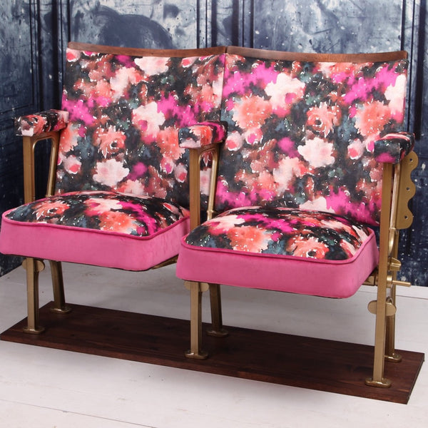 Set of two vintage cinema seats upholstered in pink floral rose velvet, with hot pink paneling and piping.