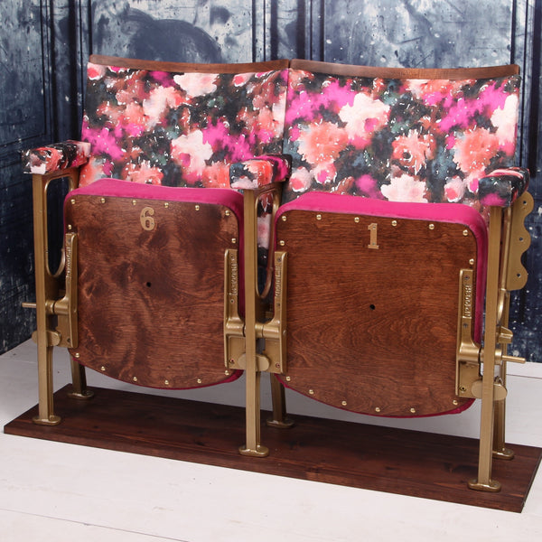 Set of two vintage cinema seats upholstered in pink floral rose velvet, with hot pink paneling and piping.