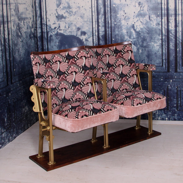 set of two vintage cinema seats upholstered in pink ostrich velvet, sat in front of a blue marbled wall