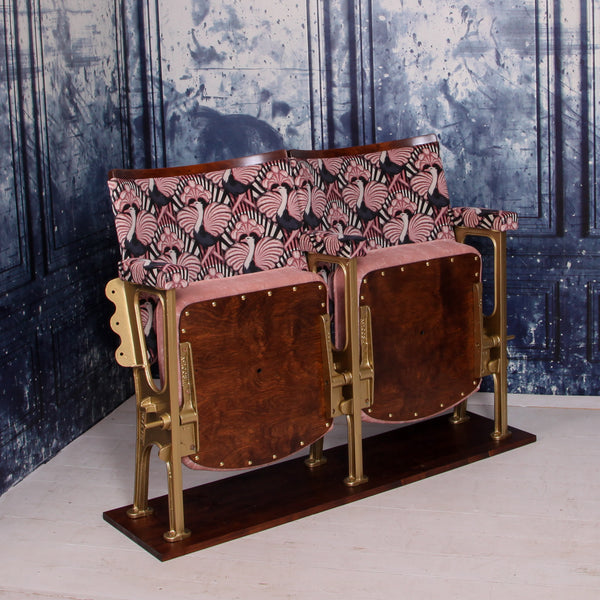 set of two vintage cinema seats upholstered in pink ostrich velvet, sat in front of a blue marbled wall