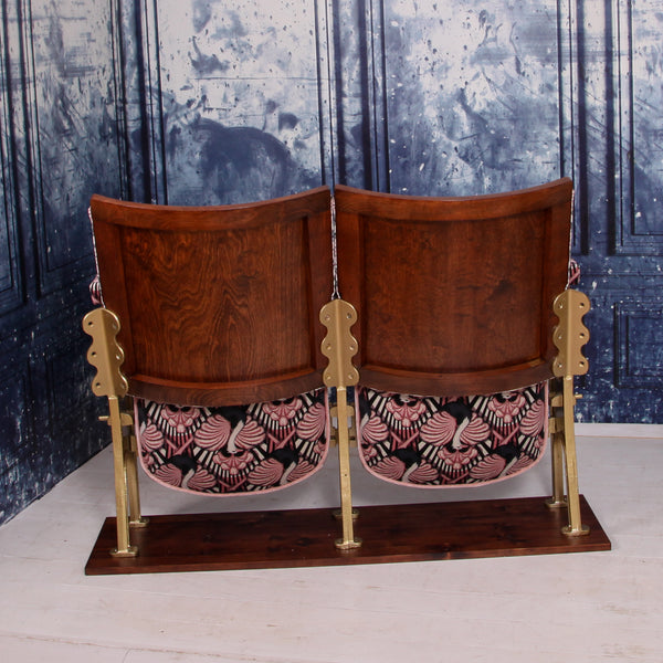 set of two vintage cinema seats upholstered in pink ostrich velvet, sat in front of a blue marbled wall
